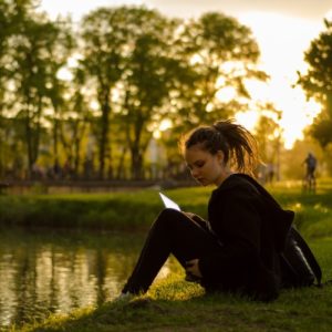 Girl reads adventure book in a park